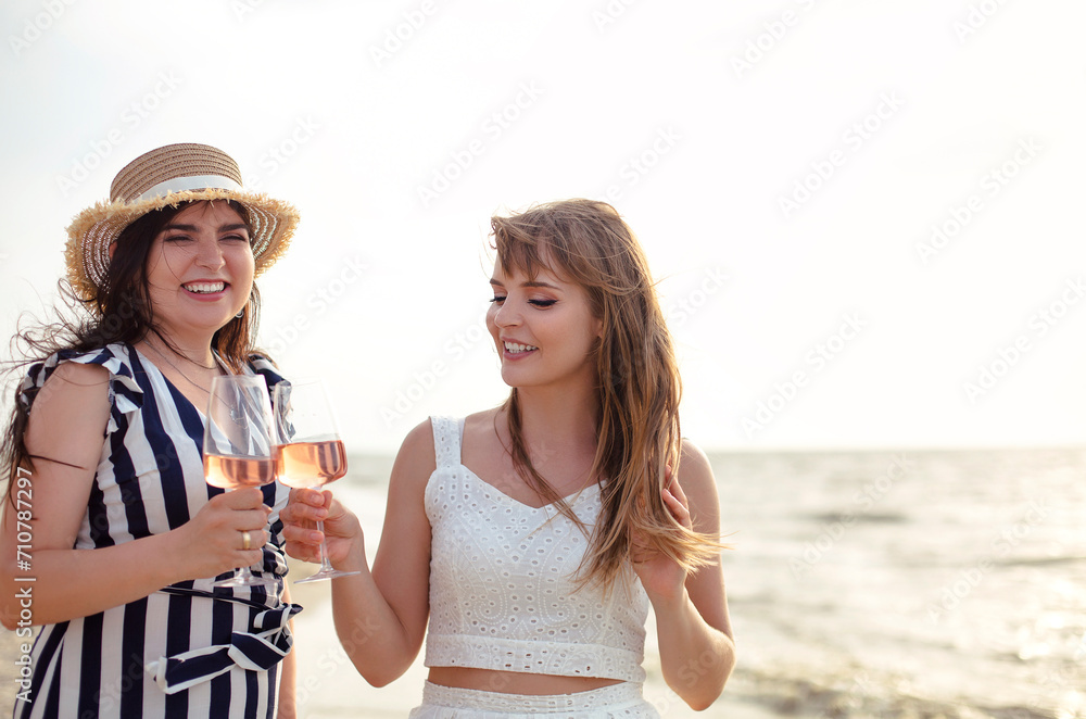 Happy adult women with wine resting on beach Happy adult women with wine resting on beach