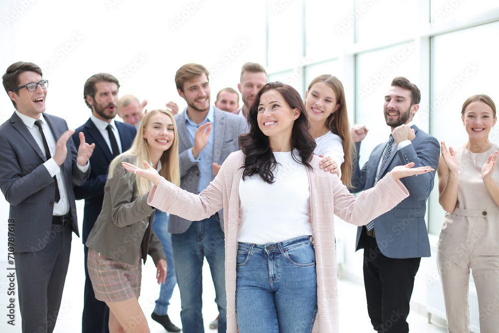 happy business lady standing in front of applauding team of employees. happy business lady standing in front of applauding team of employees.
