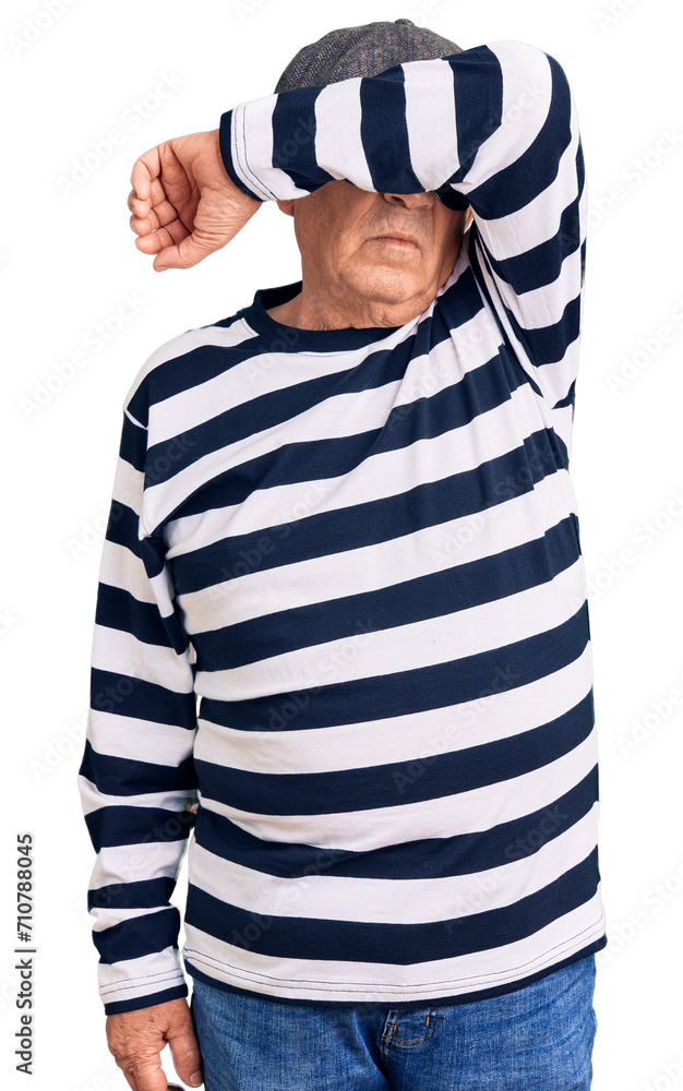 Senior handsome man wearing burglar mask and t-shirt covering eyes with arm, looking serious and sad. sightless, hiding and rejection concept Senior handsome man wearing burglar mask and t-shirt covering eyes with arm, looking serious and sad. sightless, hiding and rejection concept