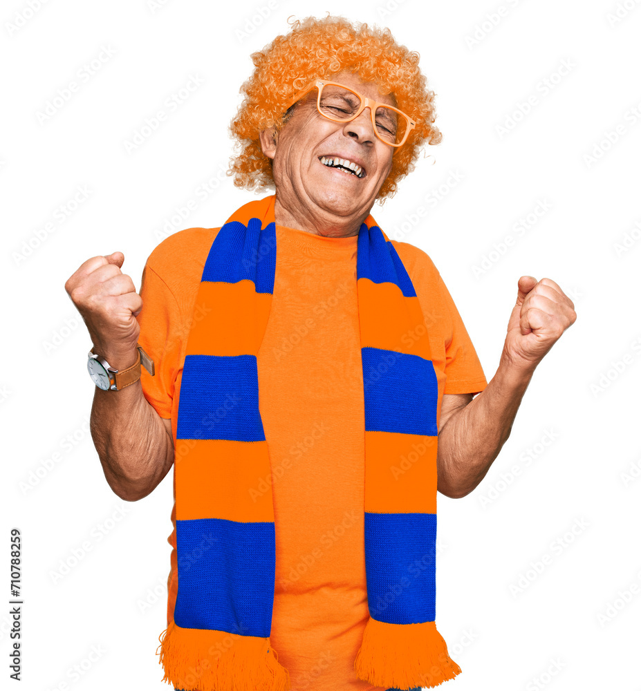 Senior hispanic man football hooligan cheering game very happy and excited doing winner gesture with arms raised, smiling and screaming for success. celebration concept. Senior hispanic man football hooligan cheering game very happy and excited doing winner gesture with arms raised, smiling and screaming for success. celebration concept.
