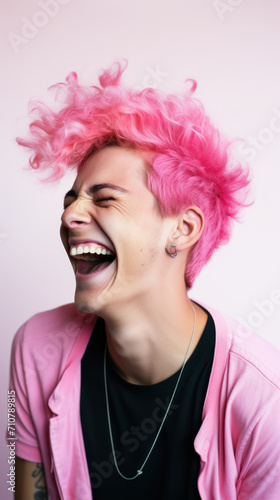 A pink-haired young man laughing closeup.
