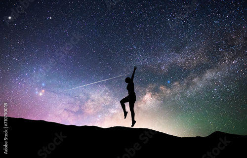 Woman silhouette dancing in the night  on the bright Milky Way Galaxy background.
