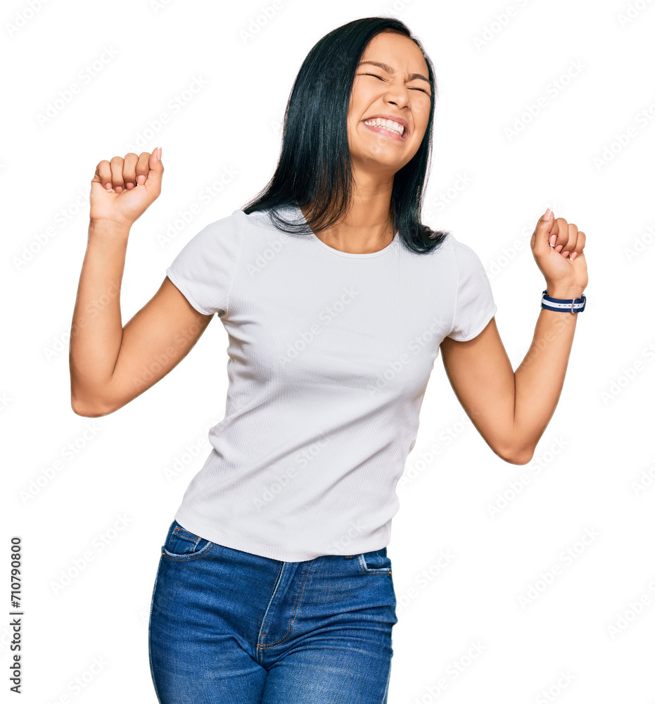 Beautiful hispanic woman wearing casual white tshirt dancing happy and cheerful, smiling moving casual and confident listening to music Beautiful hispanic woman wearing casual white tshirt dancing happy and cheerful, smiling moving casual and confident listening to music
