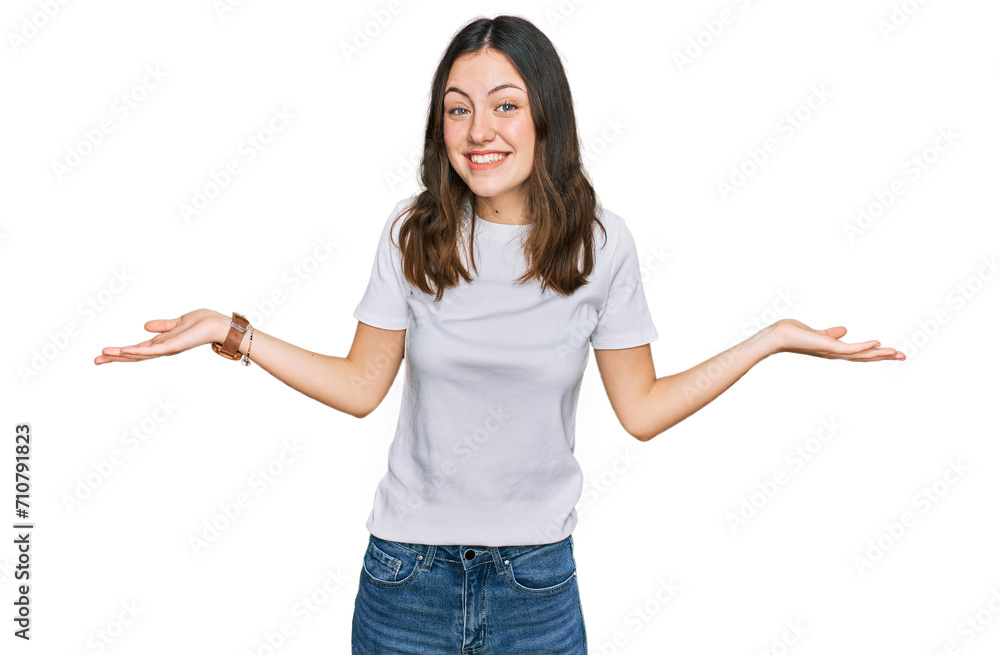 Young beautiful woman wearing casual white t shirt smiling showing both hands open palms, presenting and advertising comparison and balance Young beautiful woman wearing casual white t shirt smiling showing both hands open palms, presenting and advertising comparison and balance