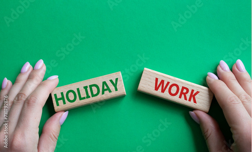 Holiday or Work symbol. Concept word Holiday or Work on wooden blocks. Businessman hand. Beautiful green background. Business and Holiday or Work concept. Copy space