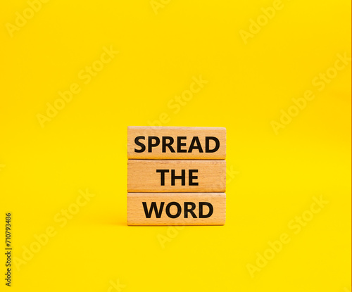 Spread the Word symbol. Concept words Spread the Word on wooden blocks. Beautiful yellow background. Business and Spread the Word concept. Copy space.