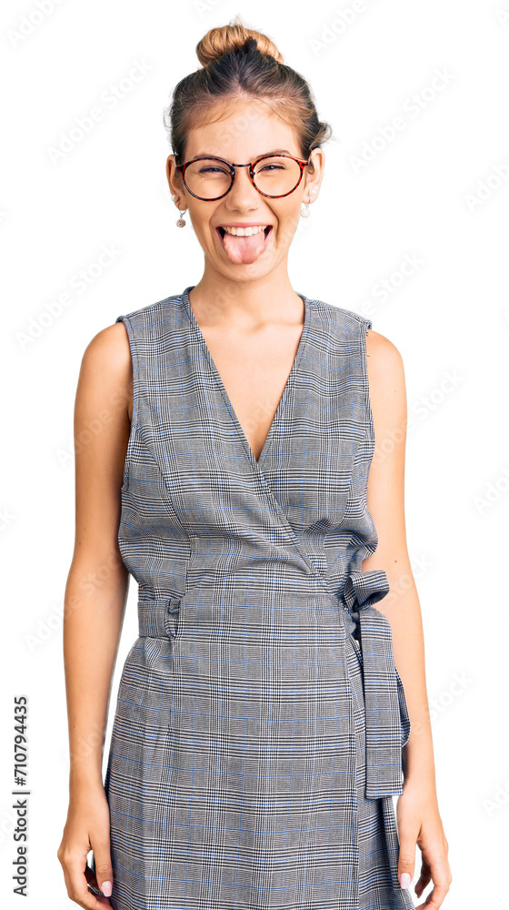 Beautiful caucasian woman with blonde hair wearing business clothes and glasses sticking tongue out happy with funny expression. emotion concept. Beautiful caucasian woman with blonde hair wearing business clothes and glasses sticking tongue out happy with funny expression. emotion concept.