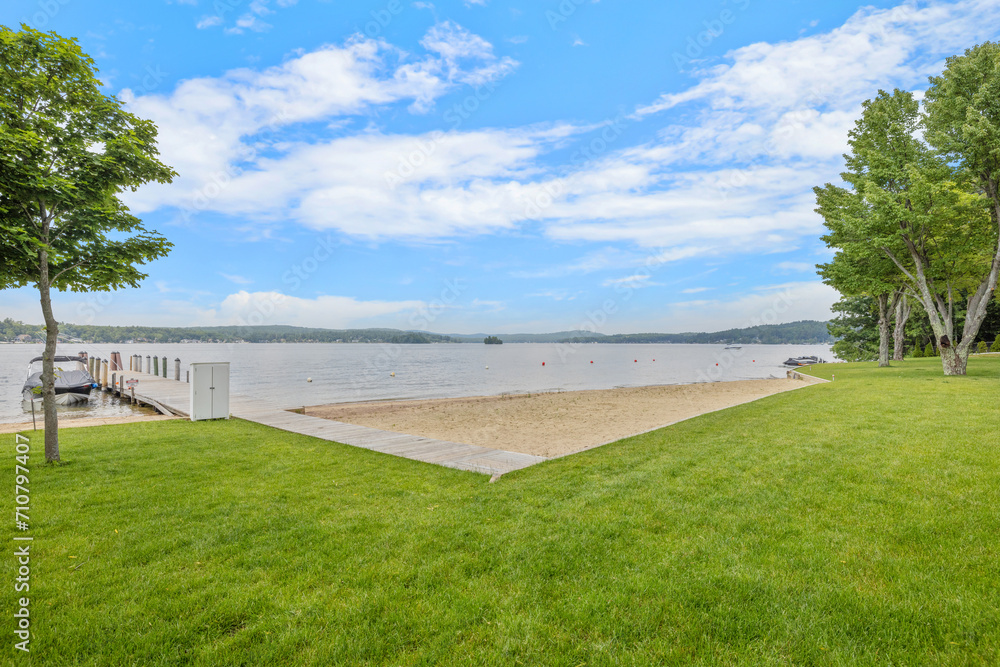 grass is scattered in front of a dock and tree covered area, in Lakeport New Hampshire. grass is scattered in front of a dock and tree covered area, in Lakeport New Hampshire.