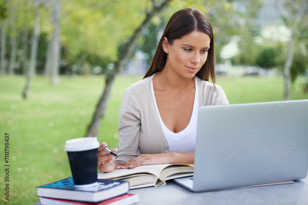 Student, books and coffee with laptop in park, technology and education by table for studying. College, young woman and commitment with outdoor by tea, focus and writing notes with online connection Student, books and coffee with laptop in park, technology and education by table for studying. College, young woman and commitment with outdoor by tea, focus and writing notes with online connection