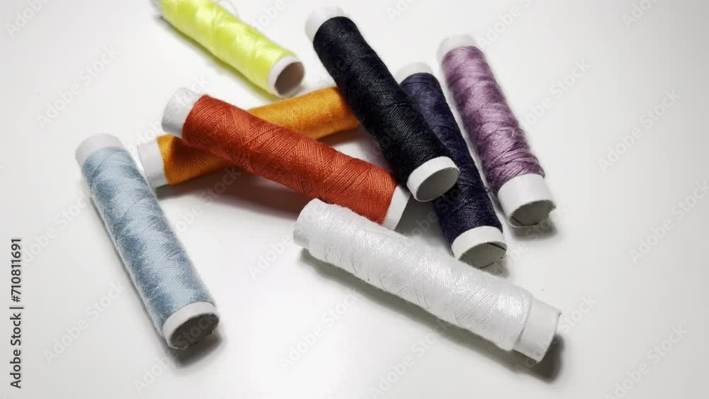 Spools of multicolored thread on a white background close up Spools of multicolored thread on a white background close up