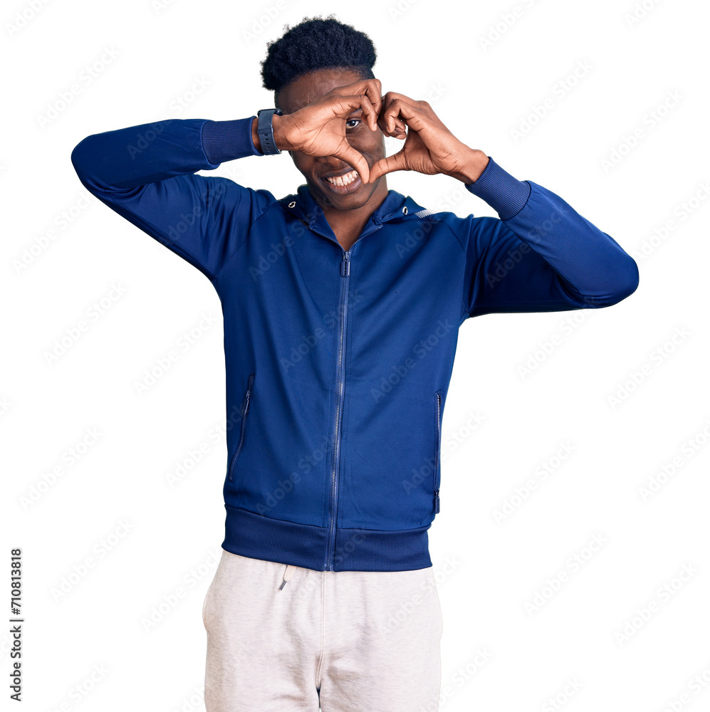 Young african american man wearing sportswear doing heart shape with hand and fingers smiling looking through sign Young african american man wearing sportswear doing heart shape with hand and fingers smiling looking through sign
