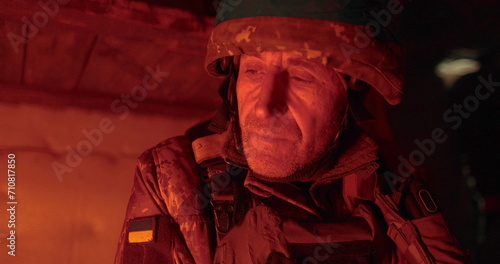 Portrait of a Ukrainian chaplain in a dugout. Close-up of vee in the dark dugout.