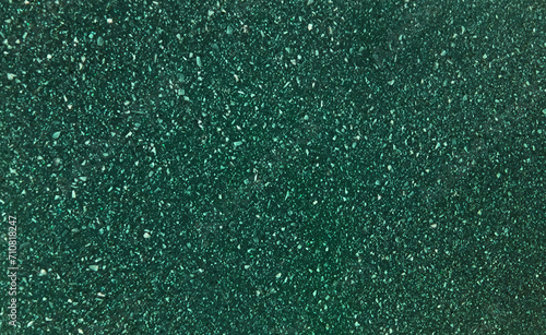 texture of grainy quartz in dark green color, close up view. green marble stone texture with splashes and white marble chips. terrazzo background for furnishing furniture.