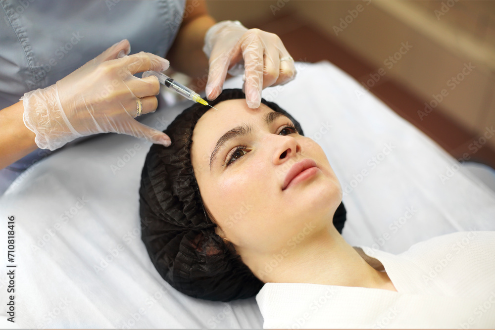 Naklejka premium Cosmetologist making injection during beauty procedure in salon