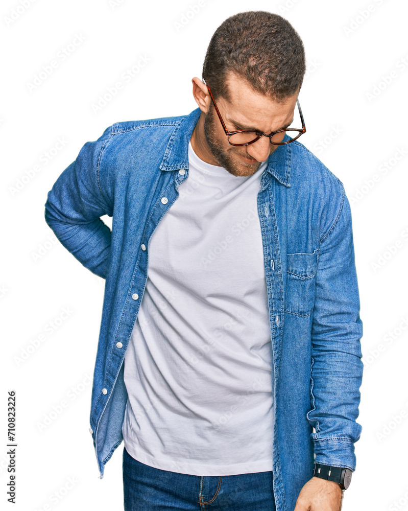 Young caucasian man wearing casual clothes suffering of backache, touching back with hand, muscular pain Young caucasian man wearing casual clothes suffering of backache, touching back with hand, muscular pain