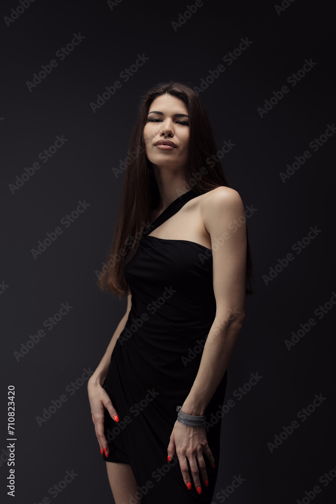An elegant woman wearing a black dress expertly poses for a captivating photograph.