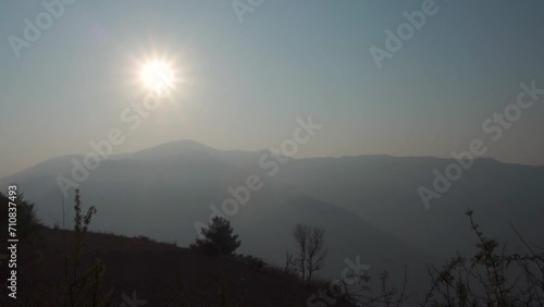 The morning sun shines down on the Naag Tibba Mountain, located in Uttarakhand, India, creating a hazy atmosphere, creating a hazy atmosphere. photo