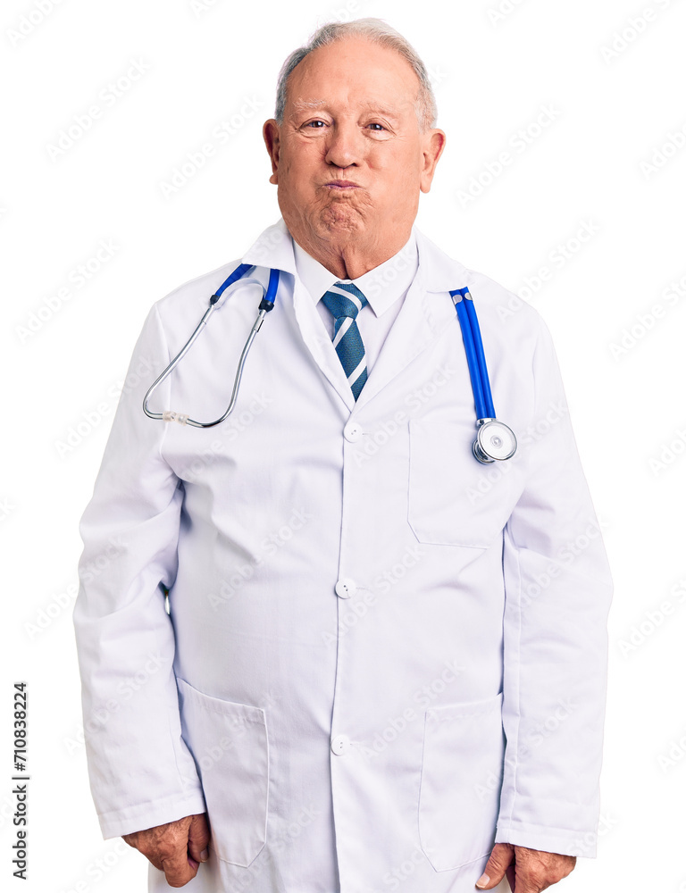 Senior handsome grey-haired man wearing doctor coat and stethoscope puffing cheeks with funny face. mouth inflated with air, crazy expression. Senior handsome grey-haired man wearing doctor coat and stethoscope puffing cheeks with funny face. mouth inflated with air, crazy expression.