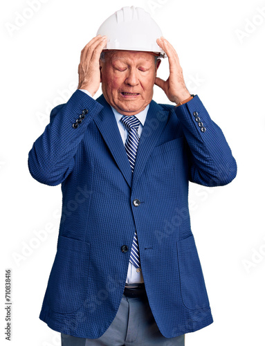 Senior handsome grey-haired man wearing suit and architect hardhat suffering from headache desperate and stressed because pain and migraine. hands on head. © Krakenimages.com