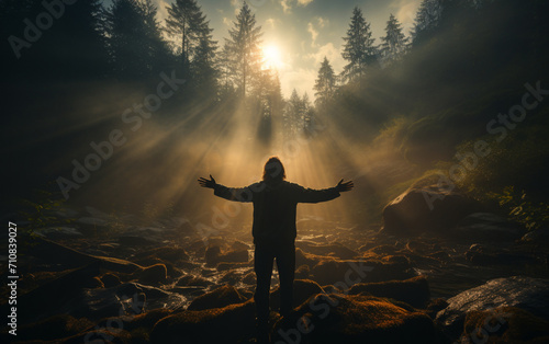 Man with open arms in dense fog see a Brocken spectre at top of the mountain, cloudy, foggy, shadow proyection, the sun is behind his back, sun lights up his back, his shadow is proyected in a dense 