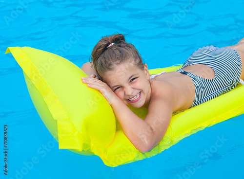 Little girl swimming on inflatable beach mattress