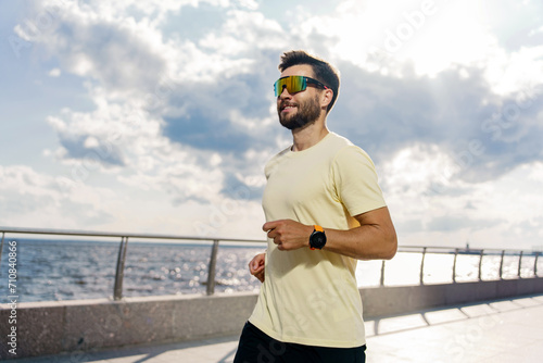 Focused runner with smartwatch enjoying a seaside jog.