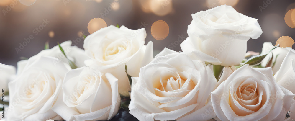 Obraz premium Beautiful white roses on a golden bokeh background.Holiday card, background for birthday, wedding, Valentine's day, Mother's day. Banner. Copy space for text