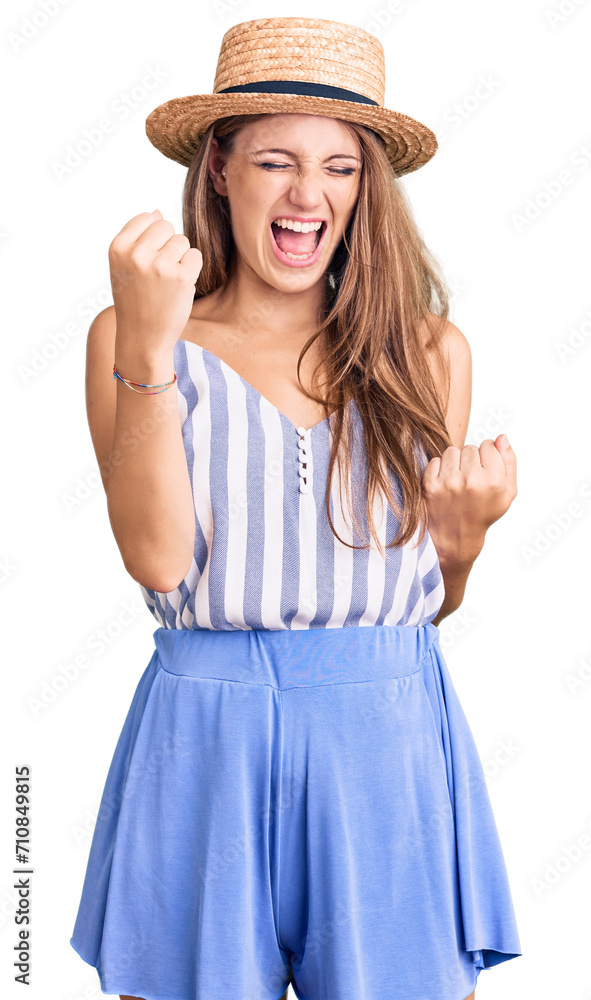 Young beautiful blonde woman wearing summer hat celebrating surprised and amazed for success with arms raised and eyes closed. winner concept. Young beautiful blonde woman wearing summer hat celebrating surprised and amazed for success with arms raised and eyes closed. winner concept.