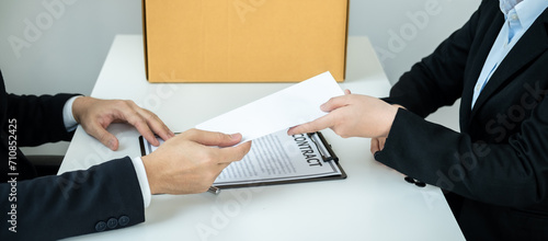 Business woman employee in suit signing on resignation letter and sending to executive while carrying packed
