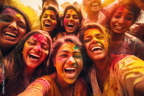 Joyful group of friends with colorful faces celebrating Holi festival of colors
