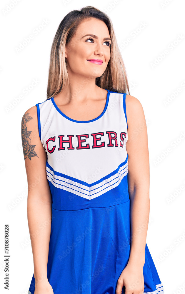 Young beautiful blonde woman wearing cheerleader uniform smiling looking to the side and staring away thinking. Young beautiful blonde woman wearing cheerleader uniform smiling looking to the side and staring away thinking.