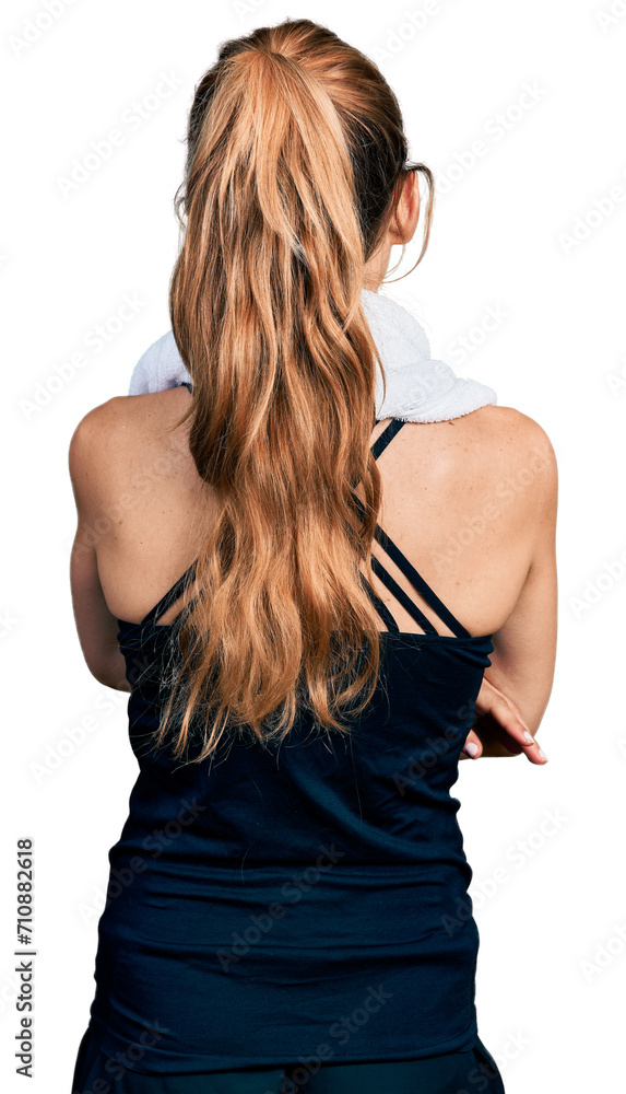 Naklejka premium Young caucasian woman wearing sportswear and towel standing backwards looking away with crossed arms