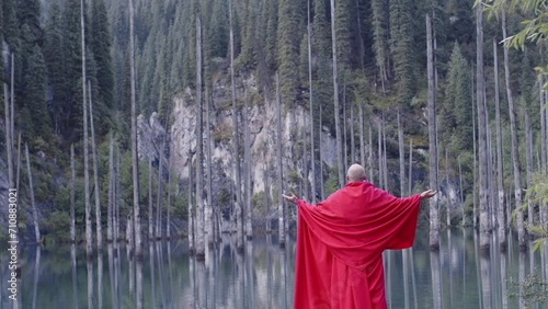 A monk in red prays in the steppe. A divine ritual.