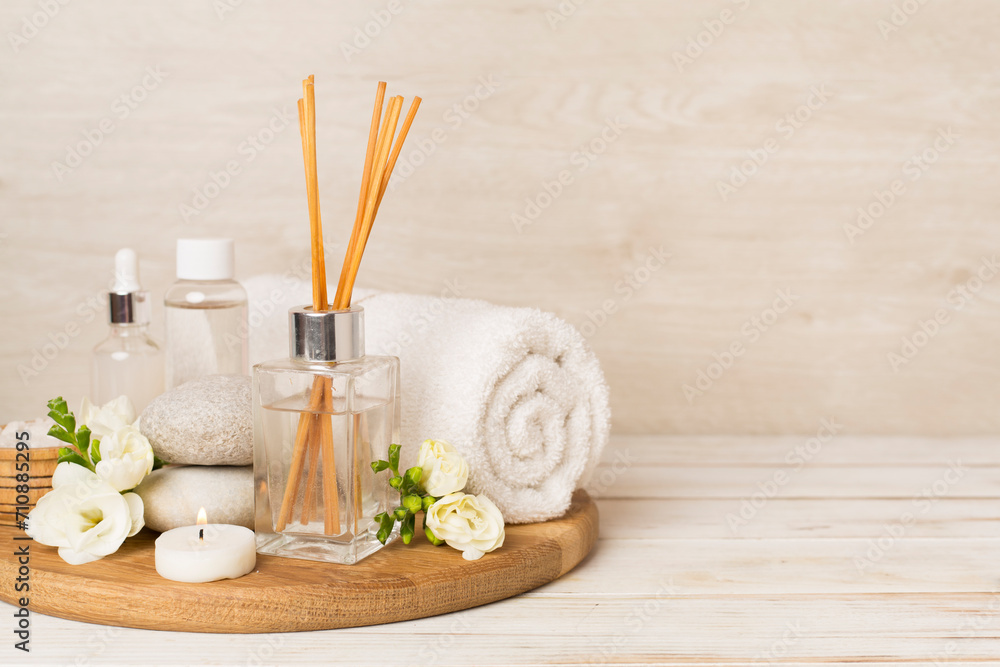 Spa composition with freesia flower and aroma diffuser on wooden table Spa composition with freesia flower and aroma diffuser on wooden table