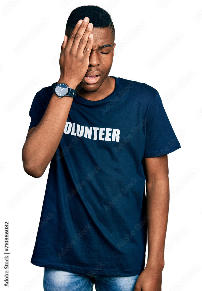 Young african american man wearing volunteer t shirt yawning tired covering half face, eye and mouth with hand. face hurts in pain. Young african american man wearing volunteer t shirt yawning tired covering half face, eye and mouth with hand. face hurts in pain.