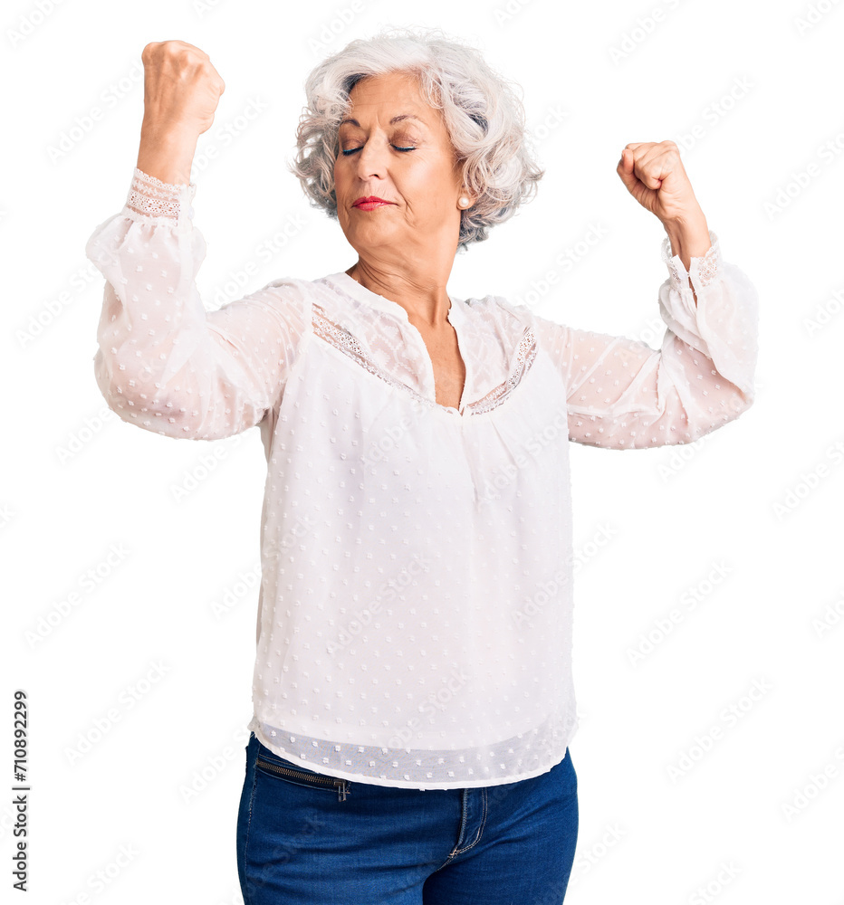 Senior grey-haired woman wearing casual clothes showing arms muscles smiling proud. fitness concept. Senior grey-haired woman wearing casual clothes showing arms muscles smiling proud. fitness concept.
