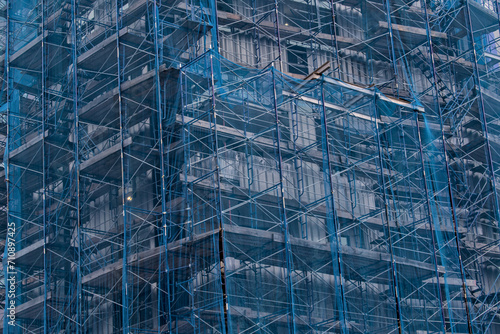 Wallpaper Mural building under construction covered in blue mesh tarp protective wrap (safety debris netting during demolition work) scaffolding high rise commercial architecture Torontodigital.ca