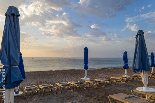 Beach by the sea on the island of Rhodes in Greece. Parasols and sunbeds on the beach.