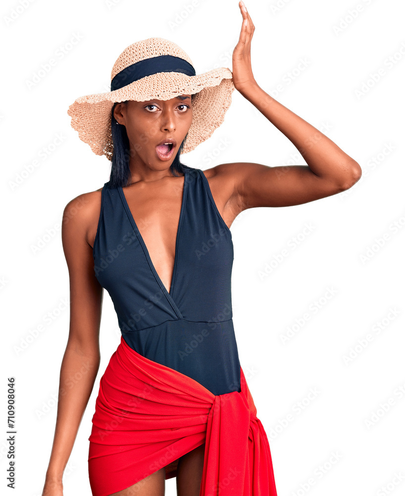 Young african american woman wearing swimsuit and summer hat surprised with hand on head for mistake, remember error. forgot, bad memory concept. Young african american woman wearing swimsuit and summer hat surprised with hand on head for mistake, remember error. forgot, bad memory concept.