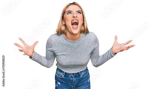 Canvastavla Young caucasian woman wearing casual clothes crazy and mad shouting and yelling with aggressive expression and arms raised