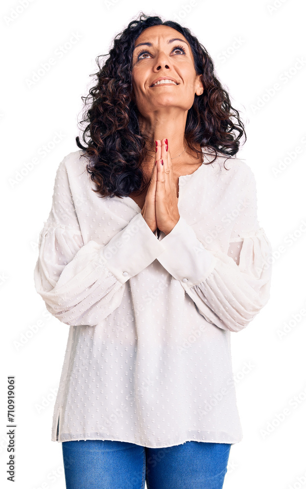 Middle age beautiful woman wearing casual sweater begging and praying with hands together with hope expression on face very emotional and worried. begging. Middle age beautiful woman wearing casual sweater begging and praying with hands together with hope expression on face very emotional and worried. begging.