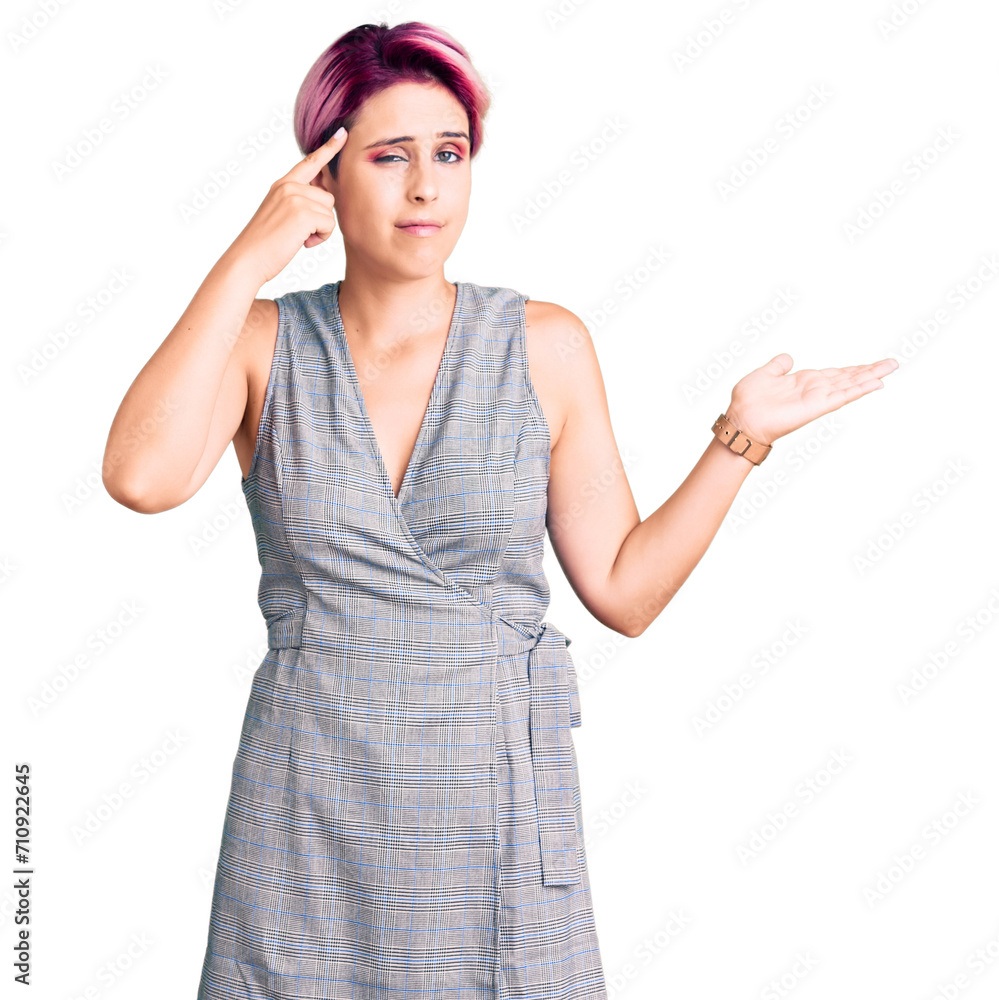 Young beautiful woman with pink hair wearing casual clothes confused and annoyed with open palm showing copy space and pointing finger to forehead. think about it. Young beautiful woman with pink hair wearing casual clothes confused and annoyed with open palm showing copy space and pointing finger to forehead. think about it.