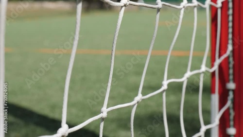 Empty goal on an empty football pitch. Video showing a slightly moving goal net on the pitch.
