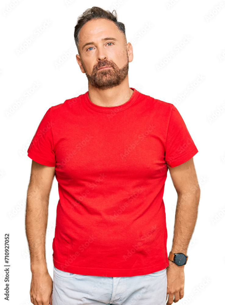 Handsome middle age man wearing casual red tshirt relaxed with serious expression on face. simple and natural looking at the camera. Handsome middle age man wearing casual red tshirt relaxed with serious expression on face. simple and natural looking at the camera.