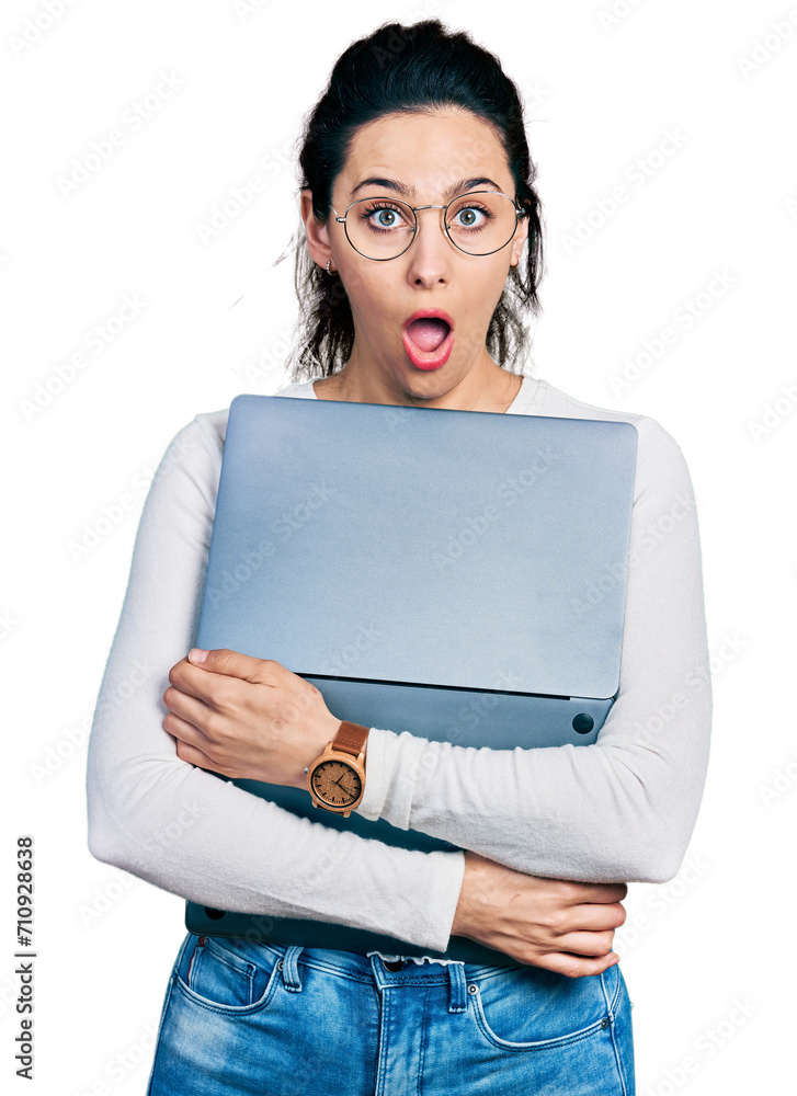 Young hispanic woman working using computer laptop afraid and shocked with surprise and amazed expression, fear and excited face. Young hispanic woman working using computer laptop afraid and shocked with surprise and amazed expression, fear and excited face.