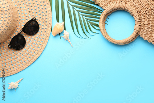 Composition with beach accessories and palm leaf on blue background