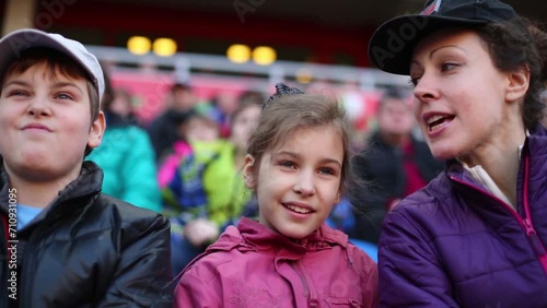 Mother, daughter and son with red pompoms look football  photo