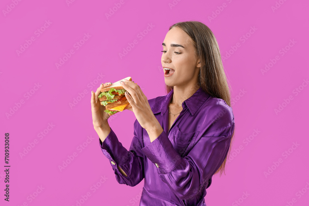 Shocked young woman with tasty sandwich on purple background Shocked young woman with tasty sandwich on purple background