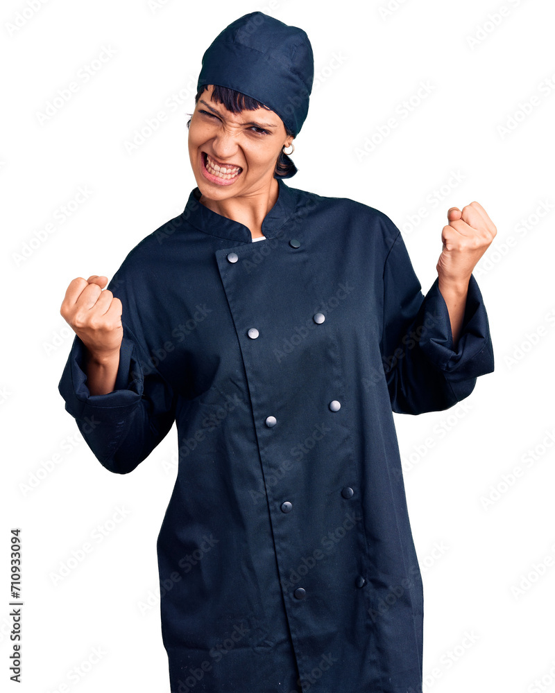 Young brunette woman with short hair wearing professional cook uniform very happy and excited doing winner gesture with arms raised, smiling and screaming for success. celebration concept. Young brunette woman with short hair wearing professional cook uniform very happy and excited doing winner gesture with arms raised, smiling and screaming for success. celebration concept.