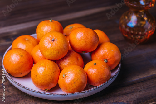 clementine mandarin fruit. mandarins on the plate on wood table.